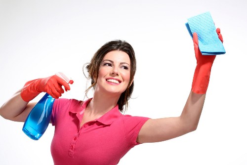 Local domestic cleaner wiping down kitchen surfaces in Watford